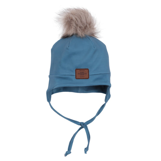 Tuque Mi-Saison - Nanö bleu avec pompon fourrure beige, liens à nouer sous le menton, style mi-saison pour enfant, vue de face.