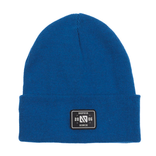 Tuque Mi-Saison - Nanö tricot bleu roi uni en double épaisseur avec écusson noir en faux cuir, vue de face.
