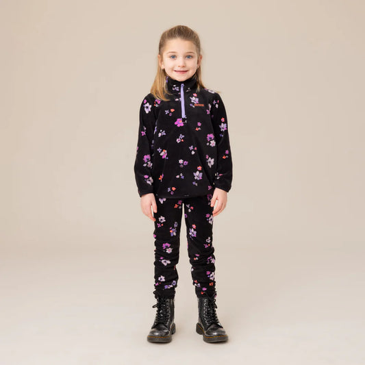 Enfant fille portant un Ensemble Thermal - Nanö noir avec motifs floraux roses et violets, style col zippé, vue de face, porté sur mannequin.