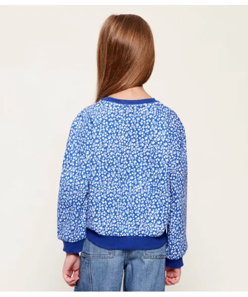 Chandail - Guess bleu à motif floral blanc, manches longues, bord-côtes bleu foncé, porté par enfant, vue de dos.