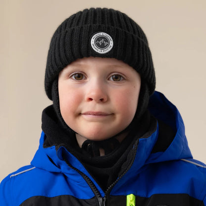 Tuque d'hiver - Peluche & Tartine noire en maille côtelée portée par un enfant sous une veste bleue vue de face