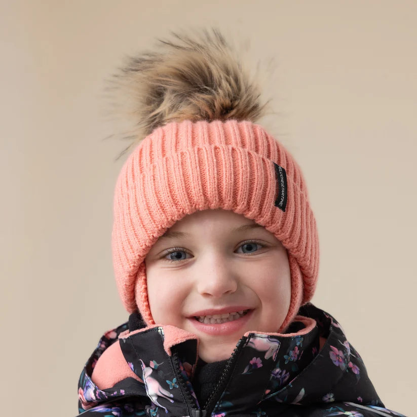 Tuque d'hiver - Peluche & Tartine rose corail côtelée avec pompon en fausse fourrure portée de face par un enfant