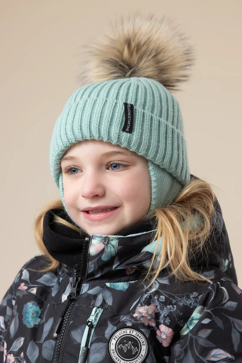 Tuque d'hiver - Peluche & Tartine, tuque tricotée vert menthe à pompon en fausse fourrure, portée par une enfant, vue de face
