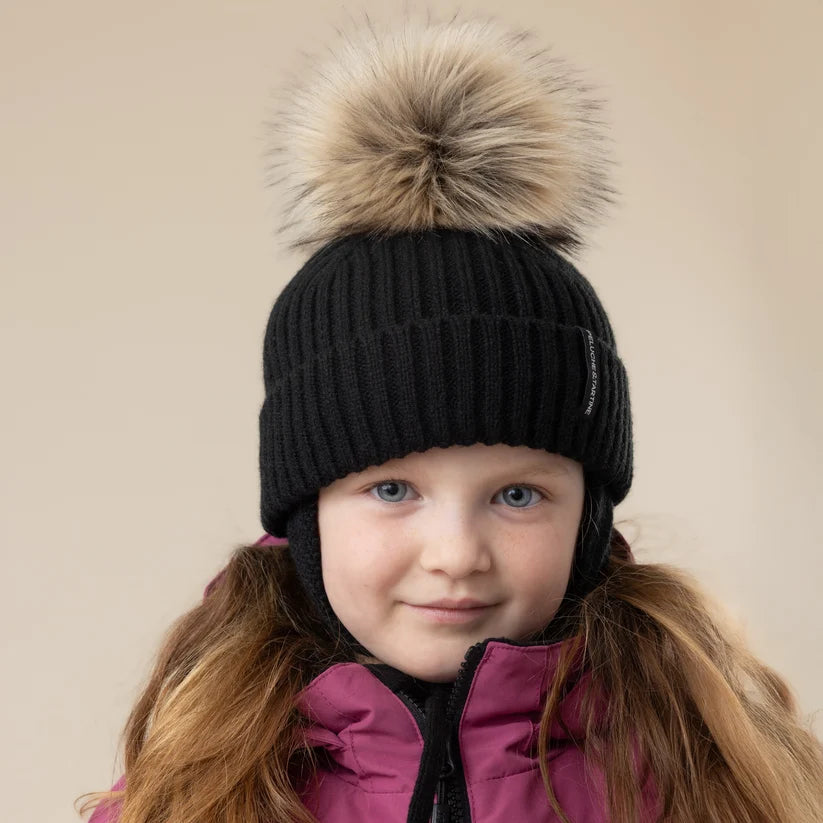 Tuque d'hiver - Peluche et Tartine, tuque noire côtelée avec pompon en fausse fourrure beige, portée par une enfant, vue de face