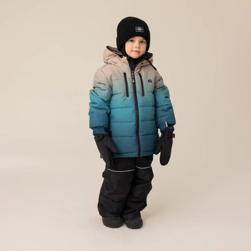 Habit de neige Antonin - Nanö bleu dégradé sur beige, tissu matelassé, porté par enfant, vue de face, avec bonnet noir et gants noirs.