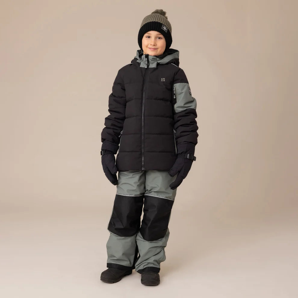 Habit de neige Antonin - Nanö porté par enfant, combinaison hiver noire et grise avec gants, vue de face sur fond neutre.