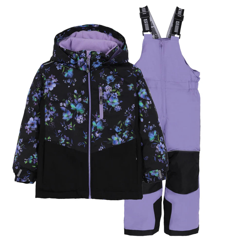 Habit de neige Lara - Nanö noir avec motif floral violet et bleu, pantalon violet avec renforts noirs, ensemble enfant, vue de face sur fond blanc.