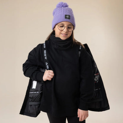 Enfant portant le Manteau d'hiver Maxifit - Nanö noir doublé, style décontracté avec bonnet violet, vue de face portée sur mannequin.
