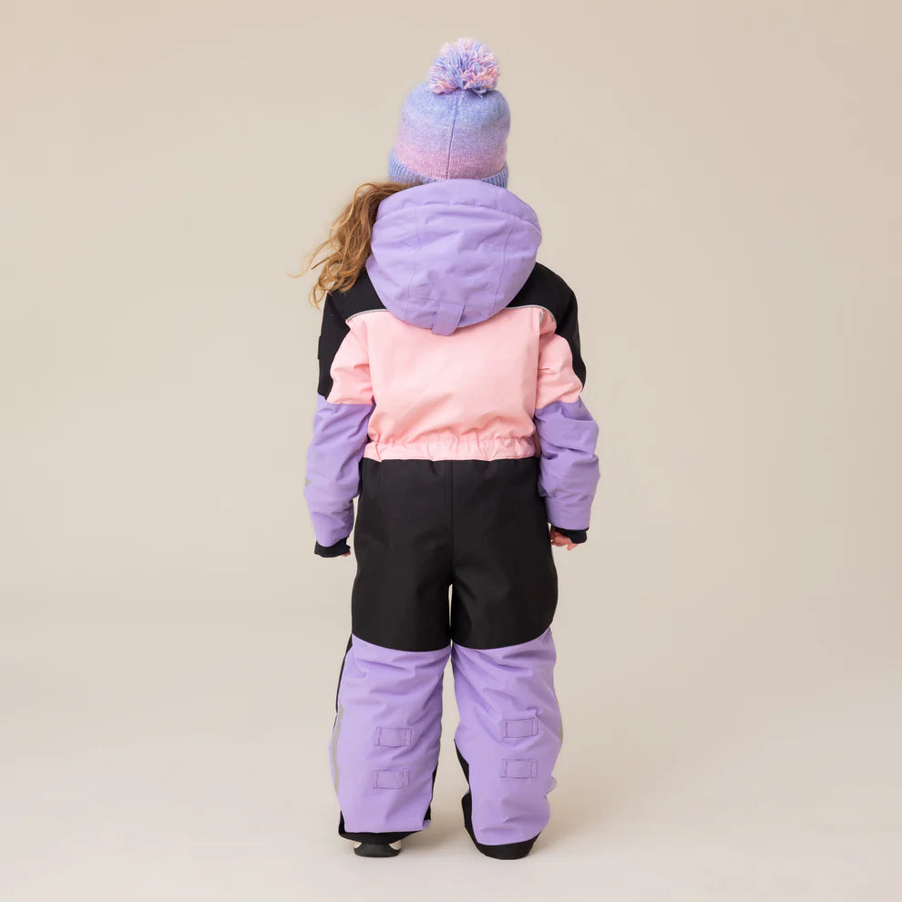 Habit de neige 1 pièce performance - Nanö en textile technique noir, rose et lavande, pour enfant, vue de dos avec capuche et bonnet assorti.