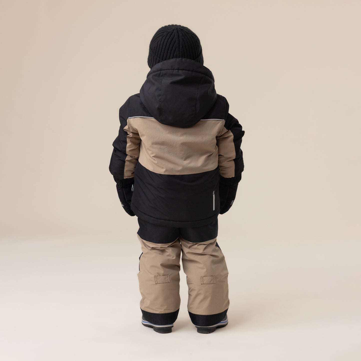 Habit de neige - Peluche & Tartine pour enfant, combinaison à manches longues noir et beige, vue de dos, tissu isolant, tenue hivernale complète.