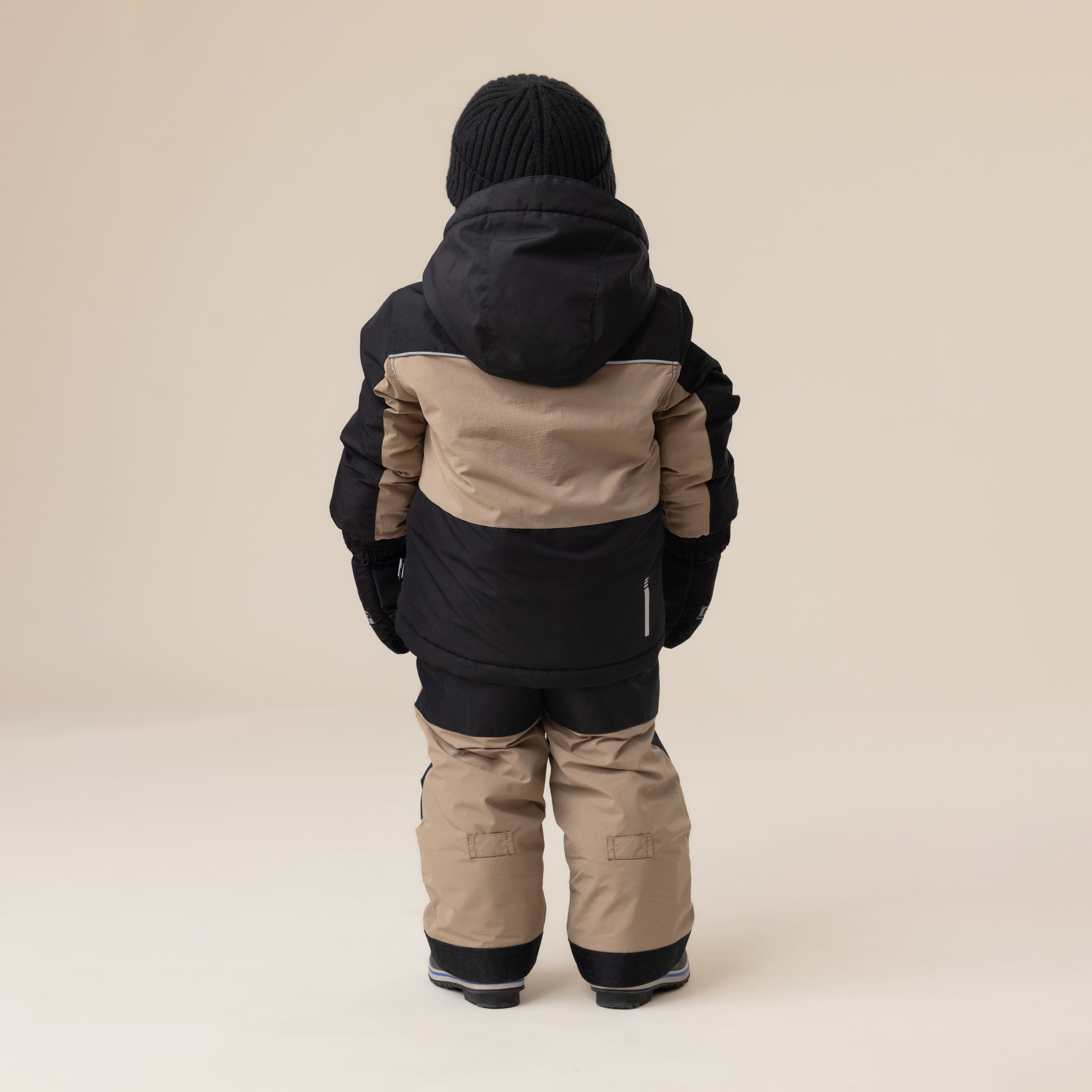 Habit de neige - Peluche & Tartine pour enfant, combinaison à manches longues noir et beige, vue de dos, tissu isolant, tenue hivernale complète.