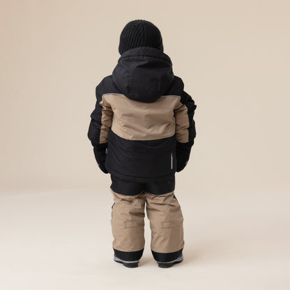 Habit de neige - Peluche & Tartine pour enfant, combinaison à manches longues noir et beige, vue de dos, tissu isolant, tenue hivernale complète.