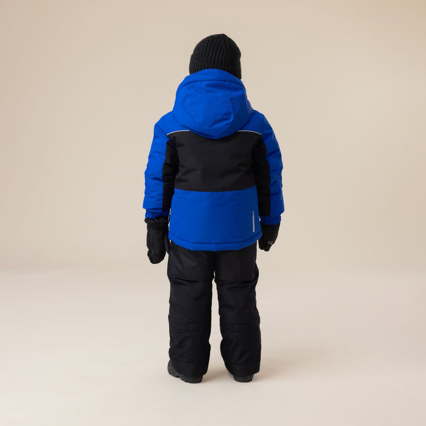 Habit de neige - Peluche & Tartine bleu et noir pour enfant, vue de dos, avec capuche, gants et bonnet noirs, style hiver, tissu isolant.