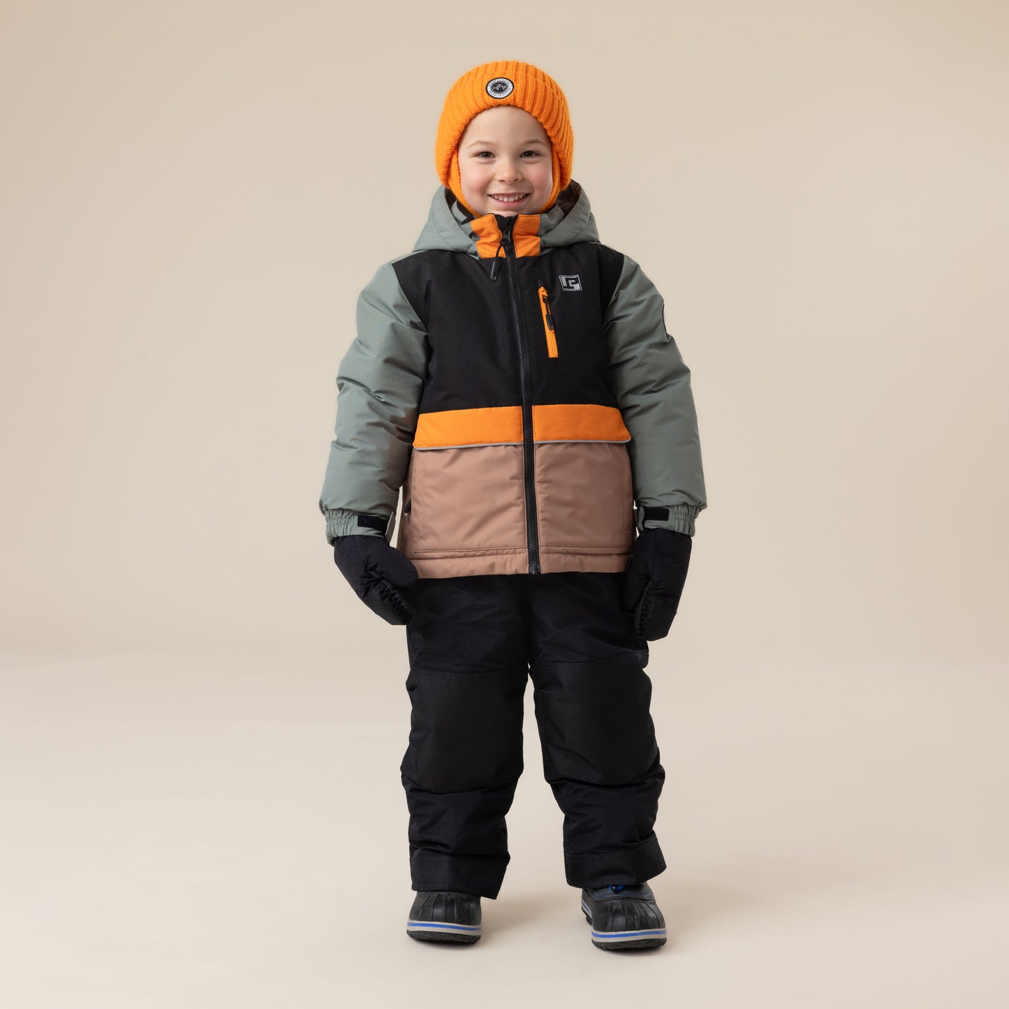 Habit de neige - Peluche & Tartine tricolore kaki, noir, orange et beige, en tissu isolant, pour enfant garçon, porté en pied, vue de face.