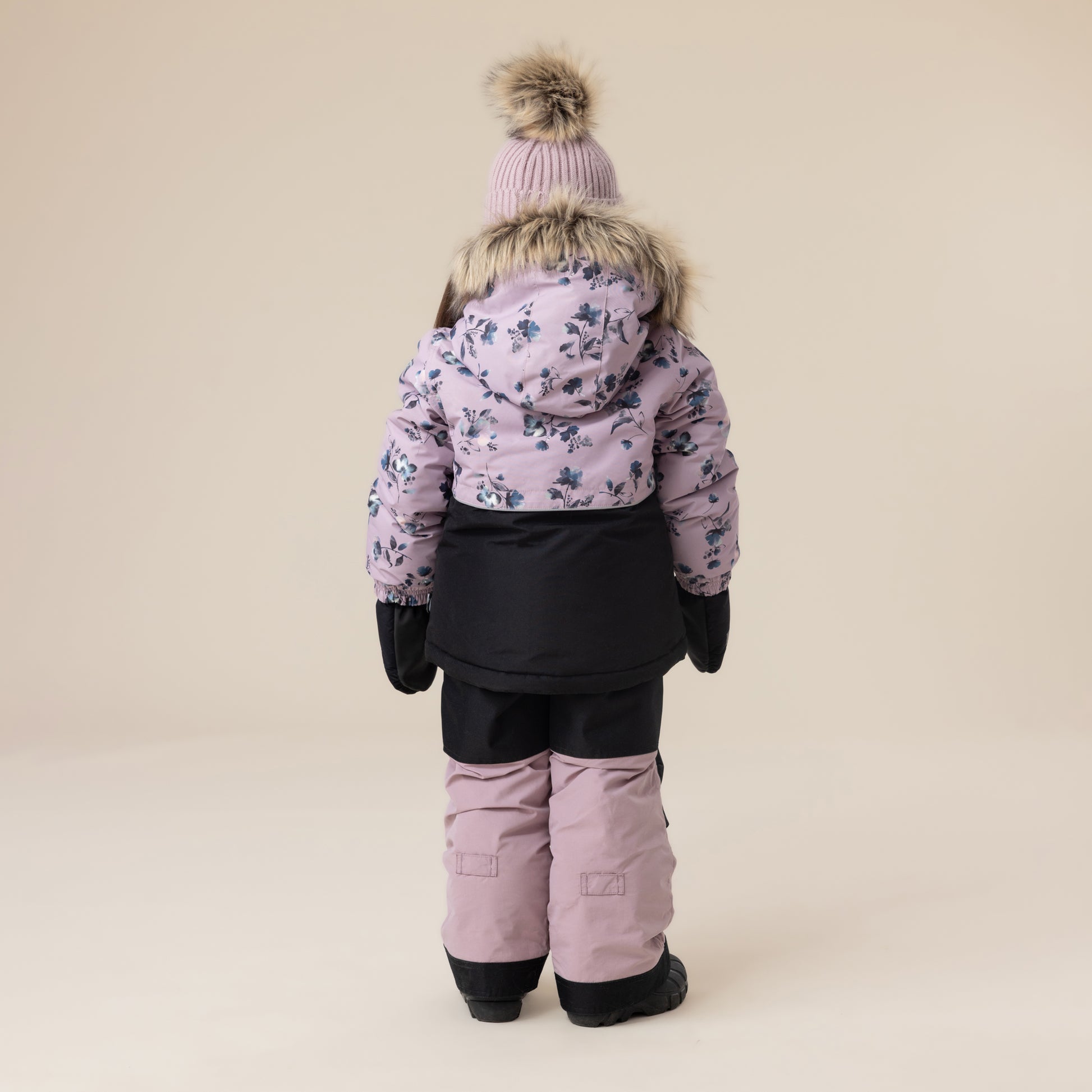 Habit de neige - Peluche & Tartine pour enfant, combinaison blanche et noire avec motifs floraux, vue de dos, capuche bordée de fausse fourrure, tenue d'hiver.