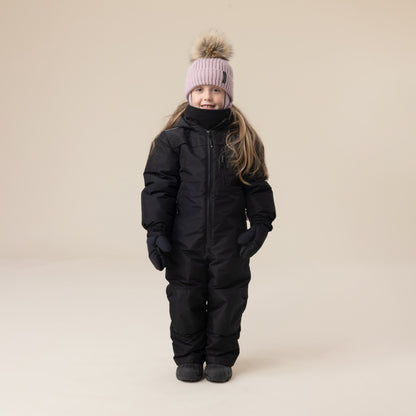 Habit de neige 1 Pièce - Peluche & Tartine (Copie) noir pour enfant, vue de face, porté par une fillette avec bonnet rose à pompon, gants noirs.