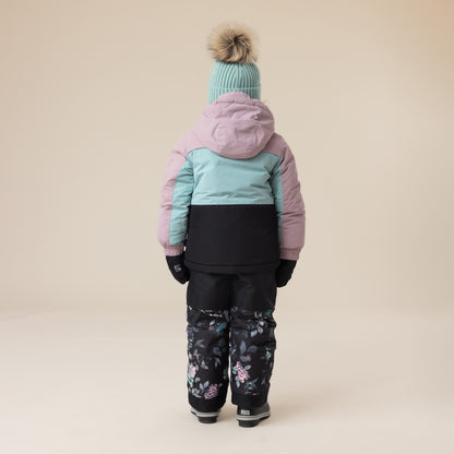 Habit de neige - Peluche & Tartine pour enfant, dos du vêtement bicolore rose et bleu pastel avec pantalon noir à motifs floraux, porté sur mannequin garçon.