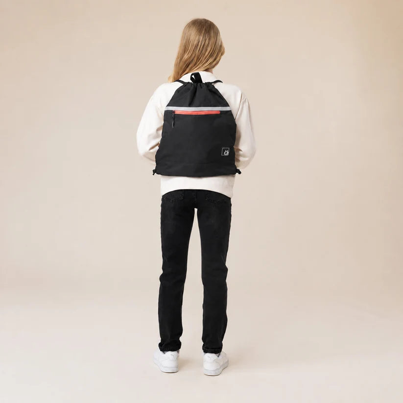 Sac à cordons - Snö noir porté sur le dos par un enfant, vue de dos, avec détail rouge sur la fermeture