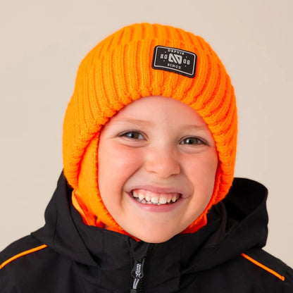 Tuque d'hiver - Nanö orange en maille côtelée portée de face par un enfant souriant avec manteau noir