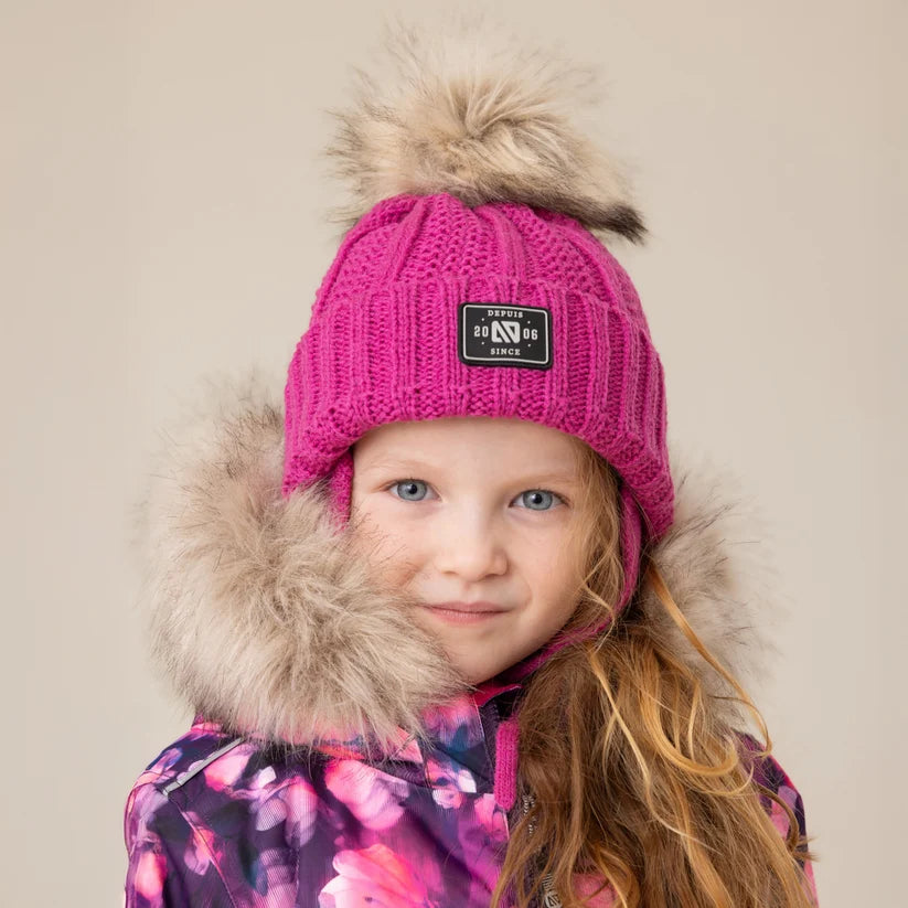 Tuque d'hiver - Nanö rose fuchsia en tricot avec pompon en fourrure synthétique portée par une fille vue de face