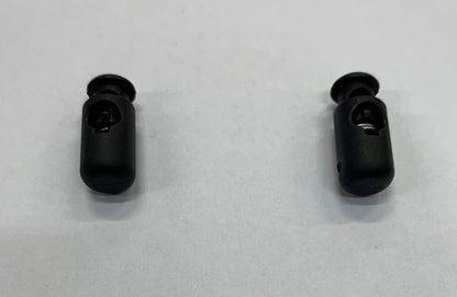 Pinces à ressorts pour lacets noires en plastique, view de dessus, paire simple sur fond blanc.