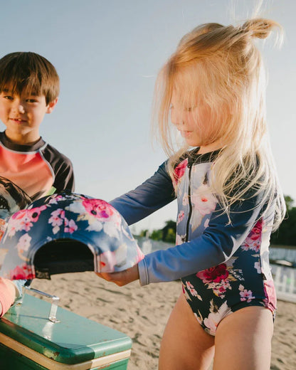 Maillot de bain - Deux Par Deux une pièce manches longues bleu marine à fleurs roses pour enfant, vue de profil porté sur mannequin fille