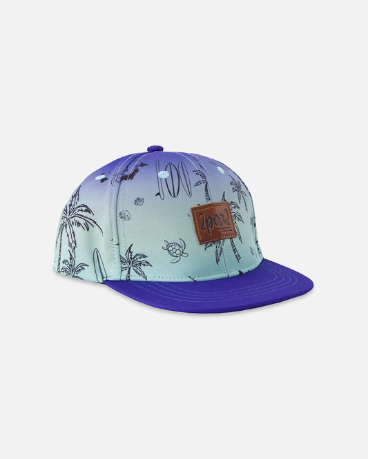 Casquette - Deux Par Deux bleue dégradée avec imprimé palmier et tortue, visière violette plate, étiquette logo, vue de côté.