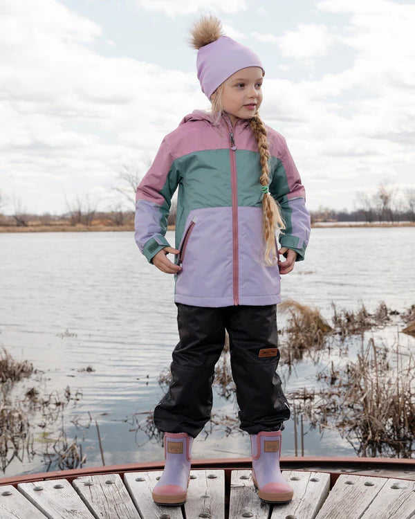Enfant fille portant un ensemble Mi-Saison - Deux Par Deux rose, vert et violet, coupe-vent imperméable, vue de face en extérieur.