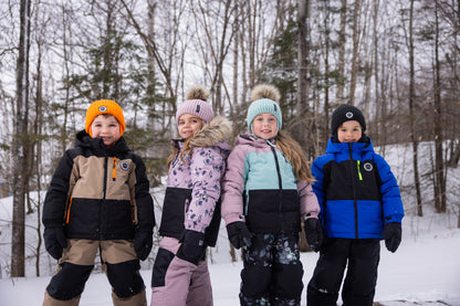 Habit de neige - Peluche & Tartine pour enfant, combinaisons chaudes multicolores en beige, noir, rose, vert et bleu, vues de trois quarts extérieure en hiver.