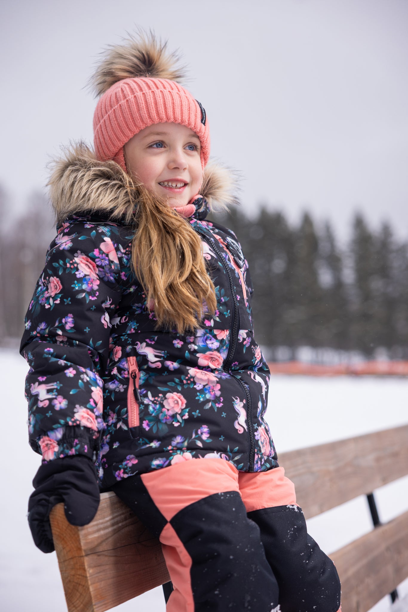 Habit de neige - Peluche & Tartine pour enfant, combinaison noire à motifs floraux et roses avec détails saumon, vue portée de face, hiver extérieur