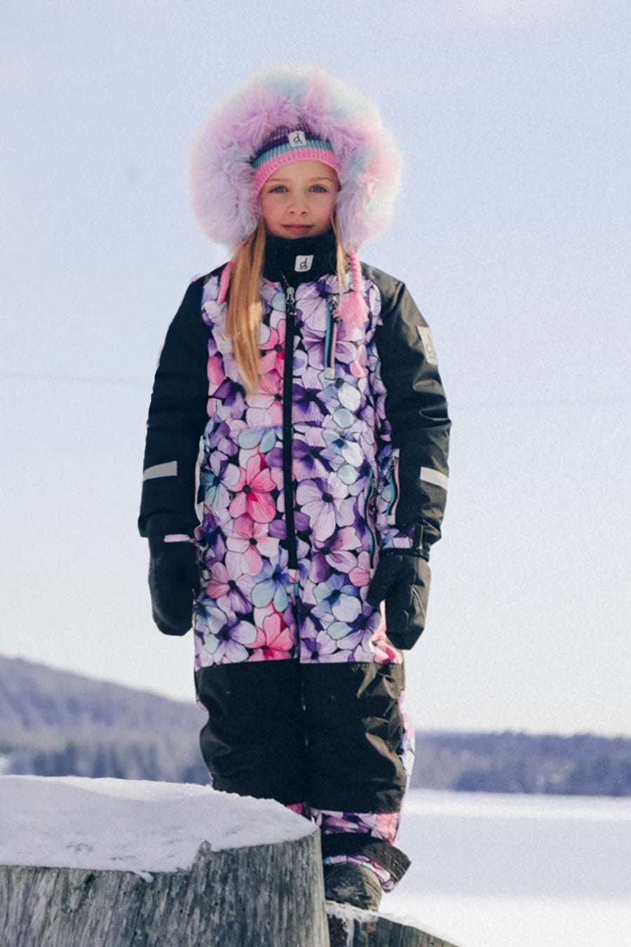 Habit de neige Play - Deux Par Deux pour fille aux motifs floraux roses et mauves avec capuchon bordé de fourrure vue de face dans la neige