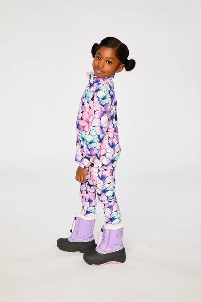 Sous-vêtements thermiques - Deux Par Deux avec motifs floraux violets, roses et bleus, pour enfant, porté de profil, en tissu chaud, avec bottes violettes.