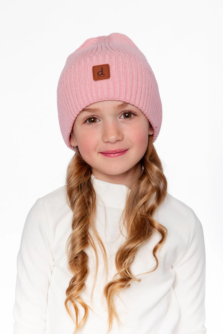Tuque Mi-Saison - Deux Par Deux rose tricotée en laine, portée par une fillette, vue de face avec détail logo en cuir brun.