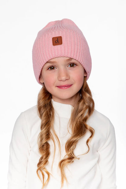 Tuque Mi-Saison - Deux Par Deux rose tricotée en laine, portée par une fillette, vue de face avec détail logo en cuir brun.
