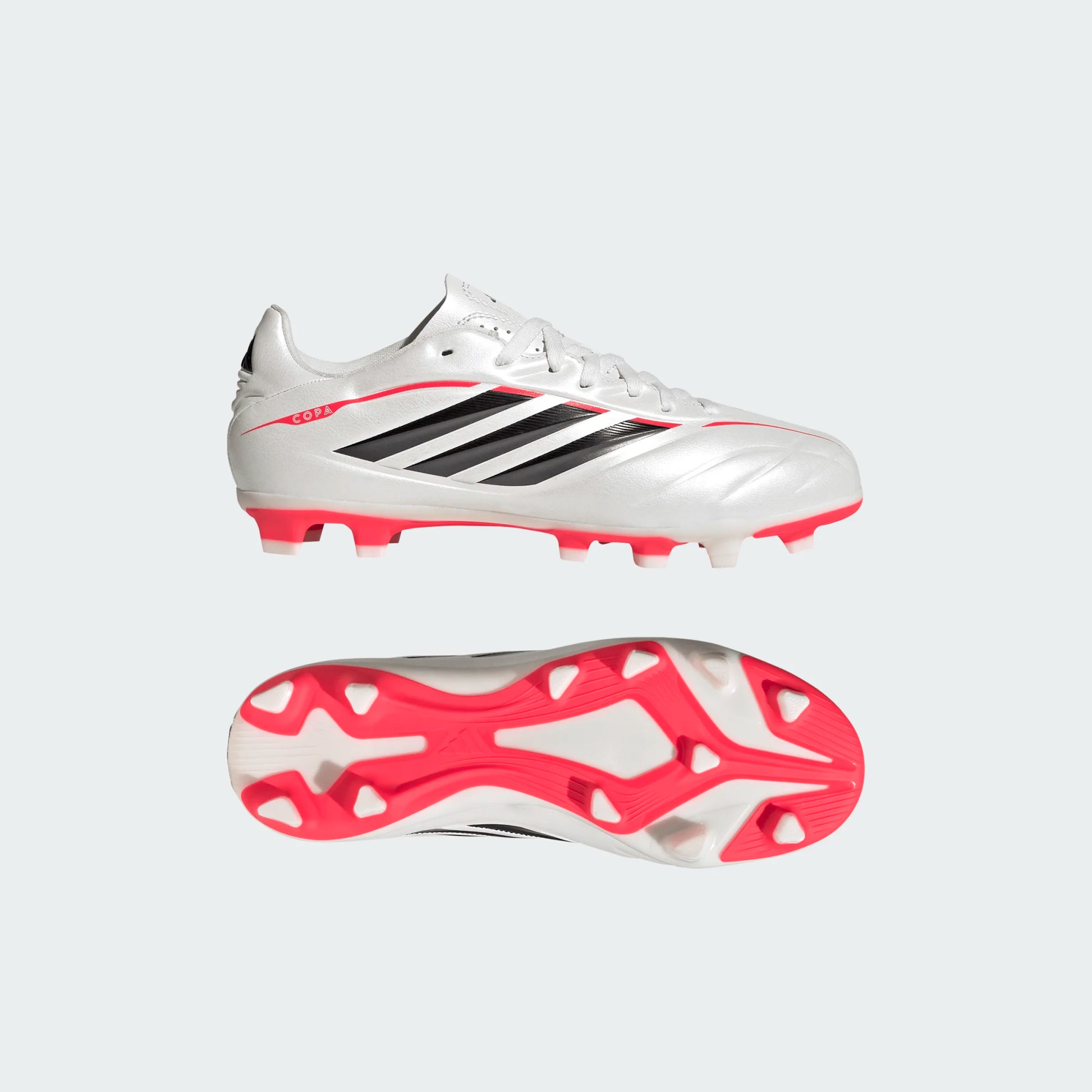 Chaussures de soccer COPA PURE IV CLUB FG - Adidas blanches, détails noirs et semelle rouge, vue latérale et dessous, terrain ferme.