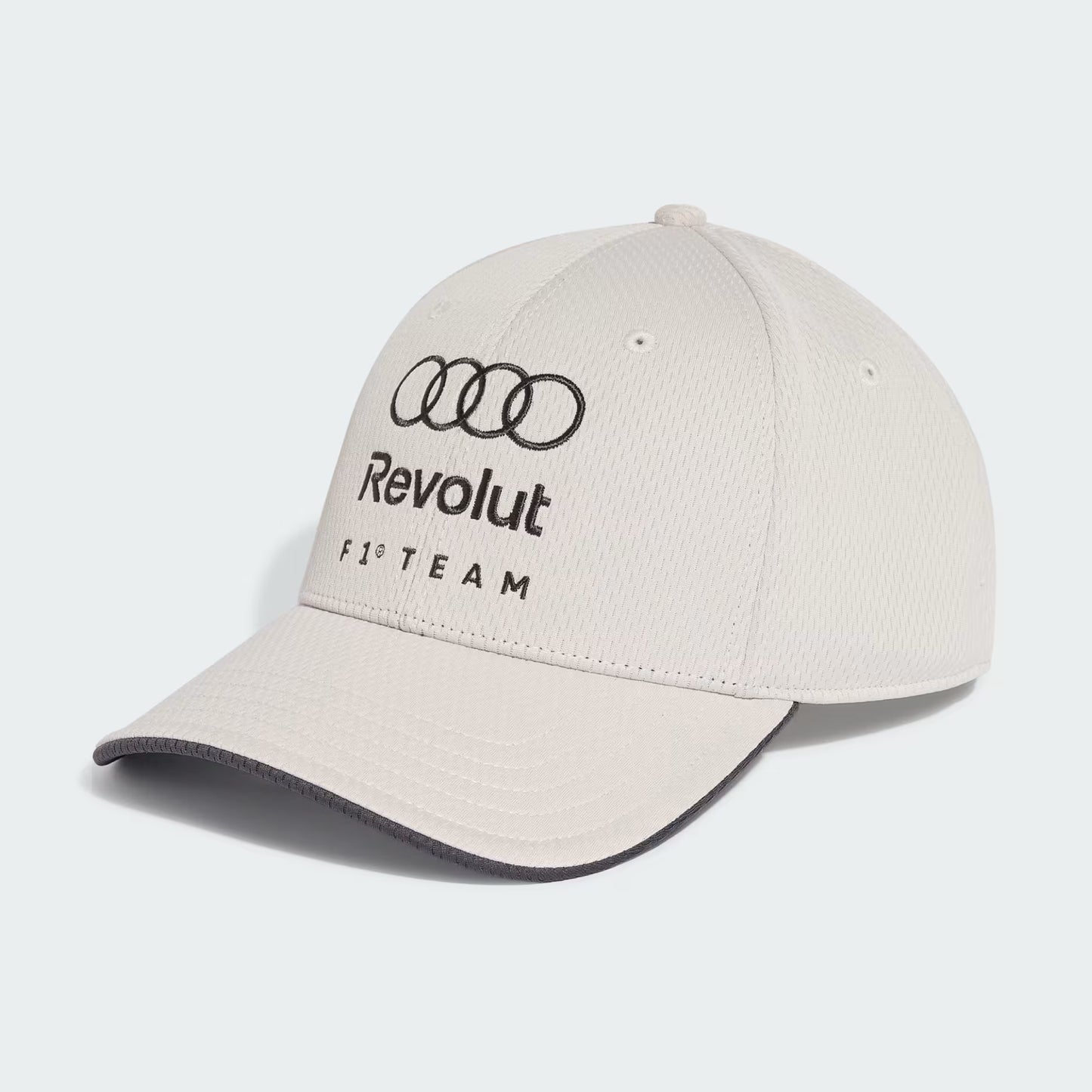 Casquette AUDI REVOLUT F1 TEAM - Adidas beige clair avec logo noir brodé, style sportif, vue de trois quarts côté droit.