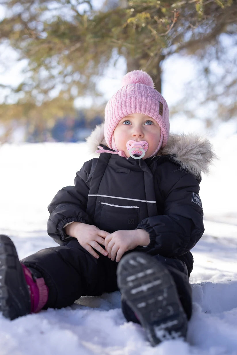 Tuque d'hiver - Nanö en maille rose avec pompon pour fillette portée de face dans la neige