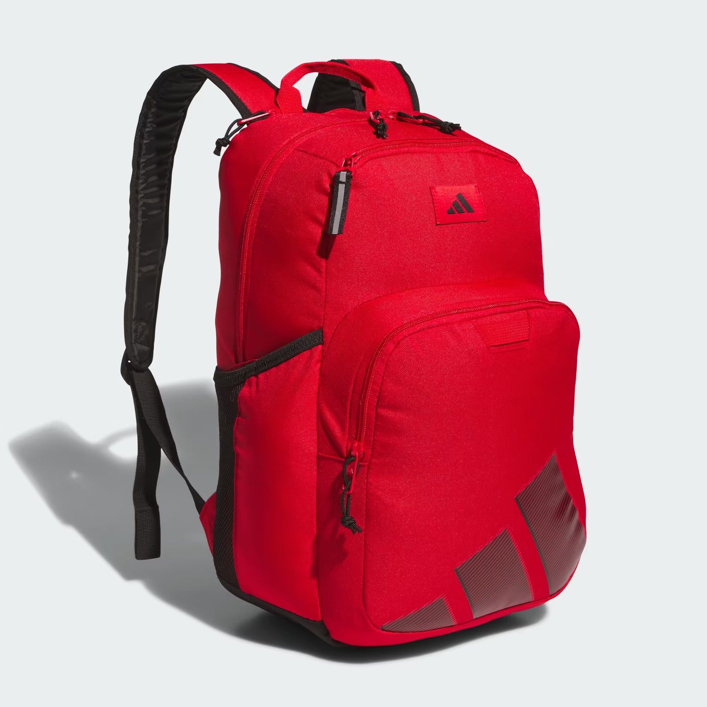 Sac à dos - Adidas rouge avec détails noirs, en polyester, style sportif avec multiples compartiments, vue de trois quarts.