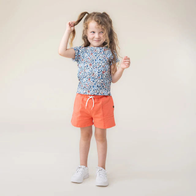 Short - Nanö orange en coton pour enfant, porté par une fille, vue de face sur fond clair.