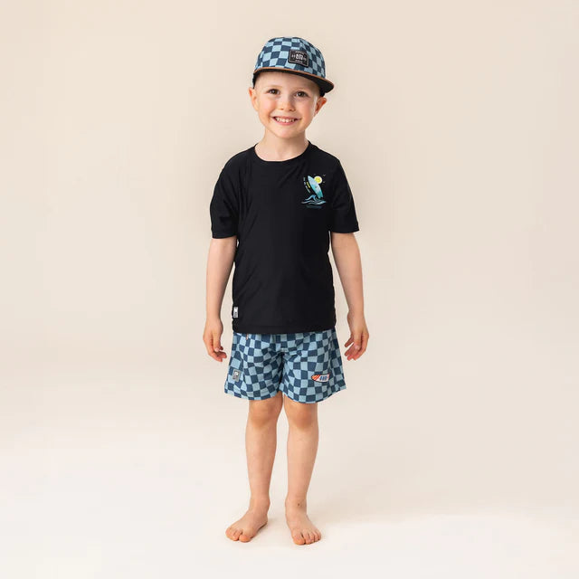 Enfant garçon portant la Casquette - Nanö à carreaux bleus et noirs, vue de face, style casquette plate.