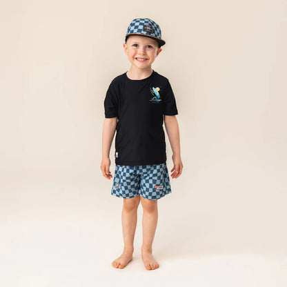 Enfant garçon portant la Casquette - Nanö à carreaux bleus et noirs, vue de face, style casquette plate.