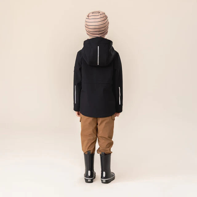 Manteau Mi-Saison Softshell - Nanö noir porté par enfant vu de dos, avec capuche et détails réfléchissants, style outdoor.