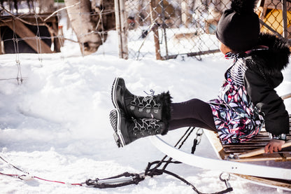 Bottes d'hiver - Acton Cortina noires en cuir synthétique et fourrure, fille, vues profil et extérieur, assise sur une luge