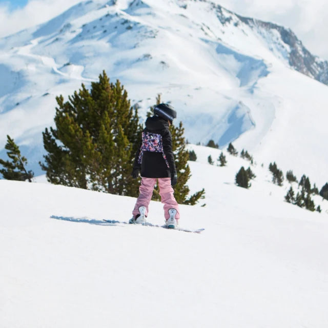 Manteau d'hiver - Roxy noir porté de dos par une fille en tenue de ski dans un paysage enneigé
