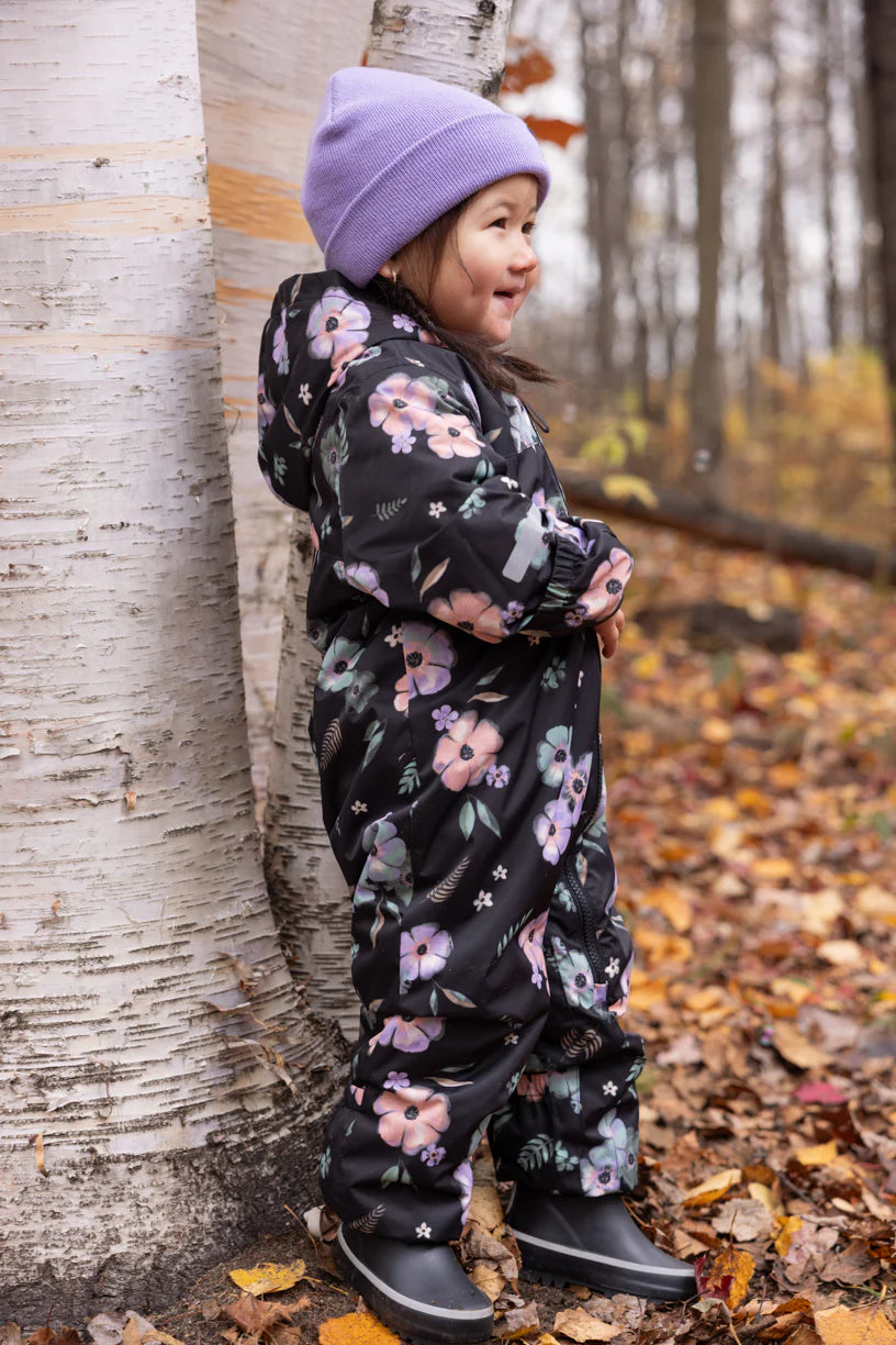 Enfant portant l'Ensemble 1 pièce - Peluche & Tartine avec motif floral, imperméable et doublé micropolaire en forêt d'automne.