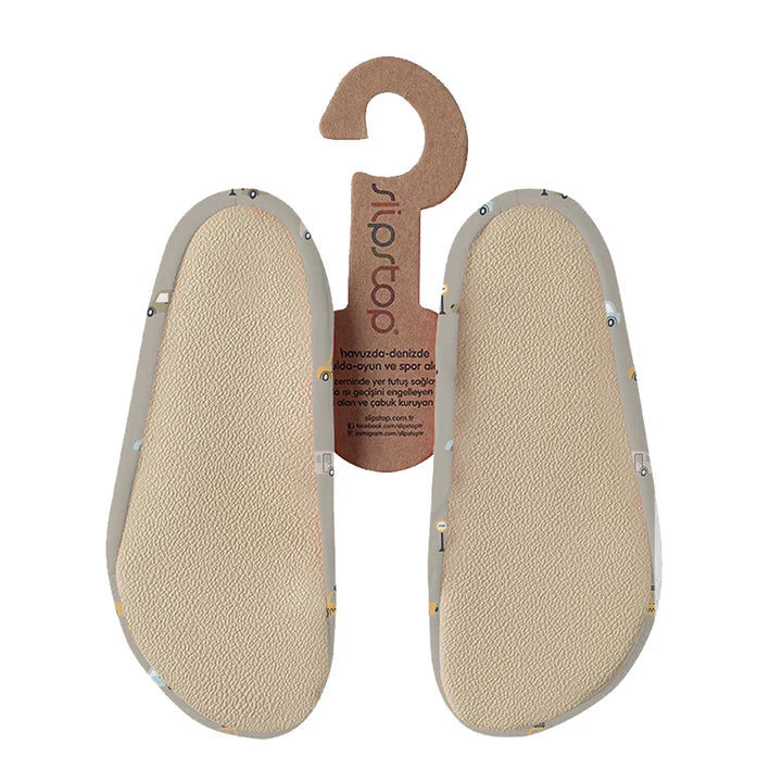Semelles antidérapantes Slip Stop beige avec motifs colorés, tissu souple, taille enfant, vue de dessous.