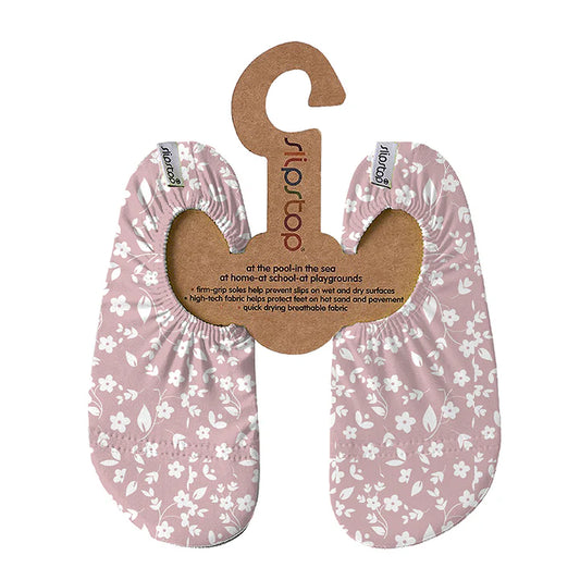 Slip Stop chaussons antidérapants rose pâle à motifs floraux blancs pour enfant, vue de face sur support en carton.