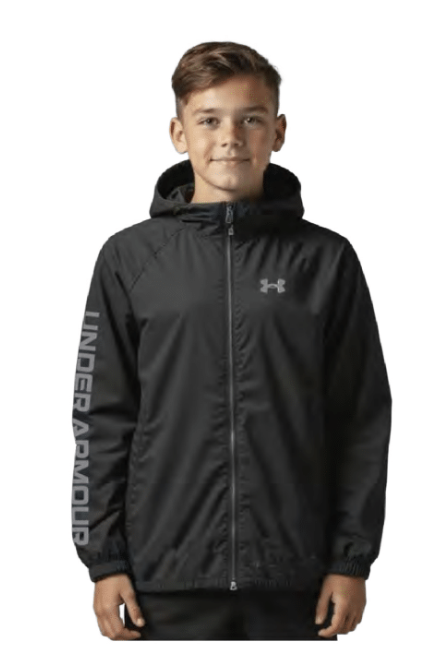 Jeune garçon portant un Manteau Mi-Saison - Under Armour noir à capuche, zippé sur le devant, avec logo gris sur la poitrine et inscription sur la manche, vue de face.