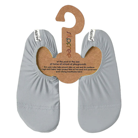 Slip Stop chaussons gris clair en tissu respirant et séchage rapide pour enfant, vue de face avec étiquette et support carton.