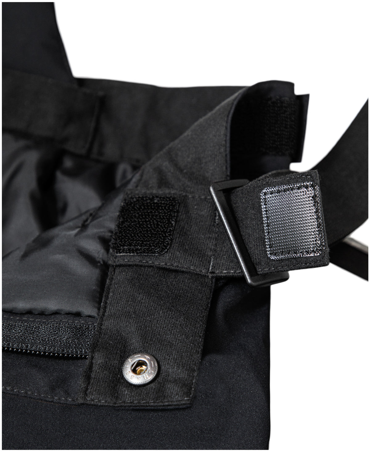 Salopette de neige - Under Armour noire, détail de la bretelle réglable et de la boucle de fixation, vue rapprochée